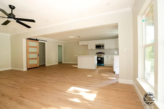 a view of a livingroom with a kitchen and a window