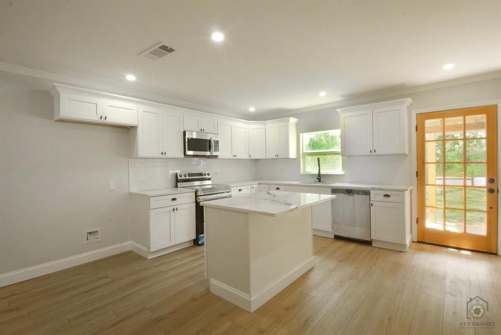 9227 Walker Road Shreveport, LA 71118 - Photo 6 of 16 a kitchen with a sink window and cabinets