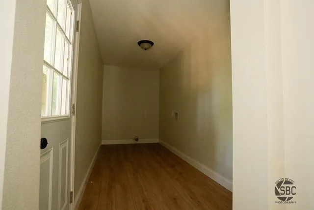 a view of a room with wooden floor and a window
