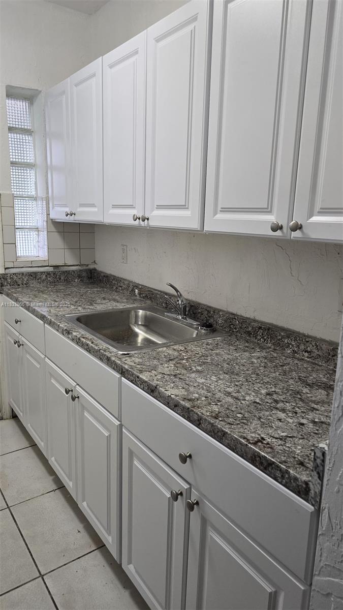 1240 Southwest 22nd Terrace, Unit 1 Miami, FL 33145 - Photo 6 of 14 a kitchen with granite countertop white cabinets and sink