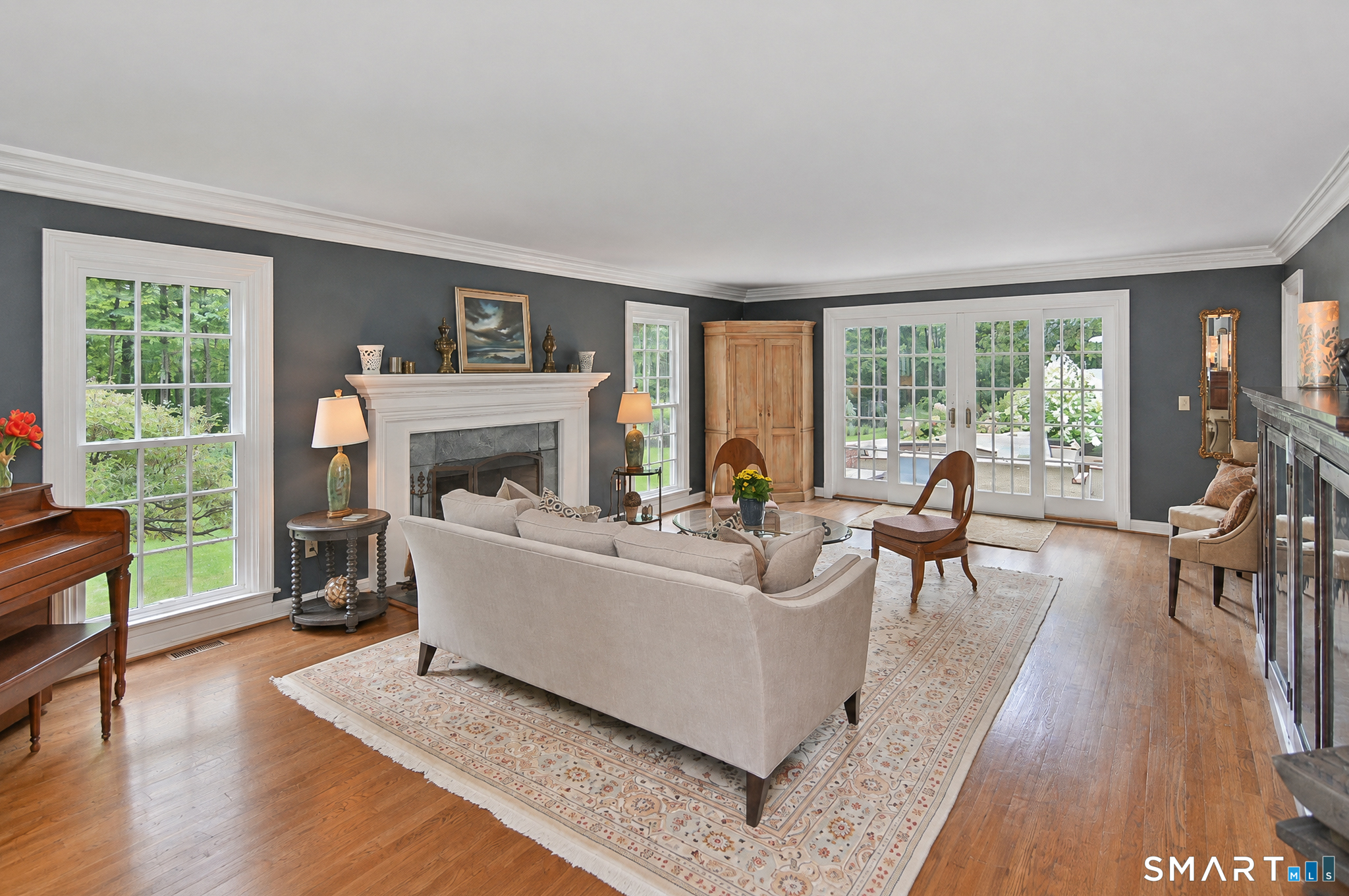 Additional view of the formal living room with fireplace, hardwood flooring and French doors providing direct access to the patio.