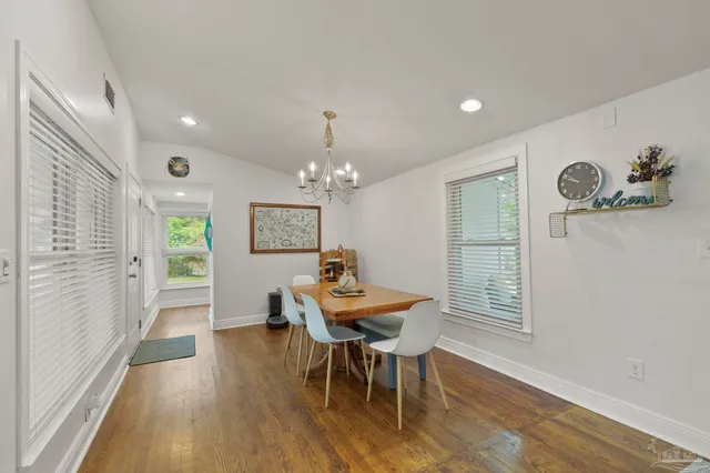 a view of a dining room with furniture a chandelier and wooden floor