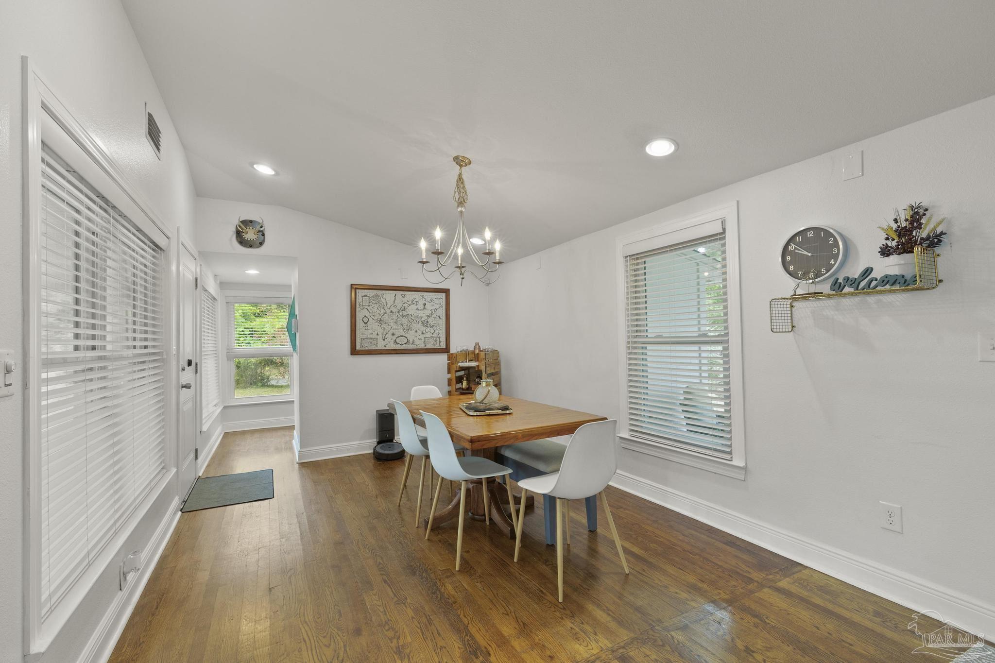 200 Clematis Street Pensacola, FL 32503 - Photo 5 of 33 a view of a dining room with furniture a chandelier and wooden floor