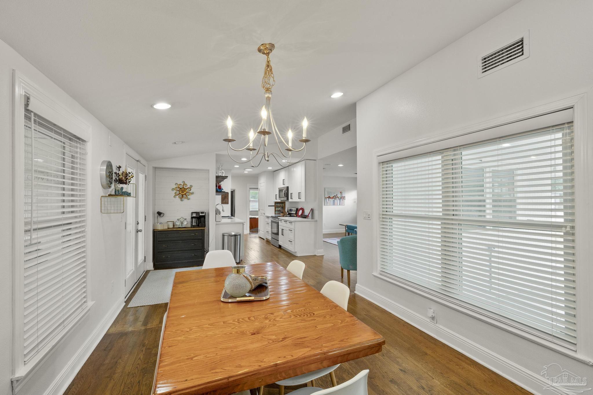 200 Clematis Street Pensacola, FL 32503 - Photo 7 of 33 a view of a dining room and livingroom with furniture wooden floor kitchen chandelier
