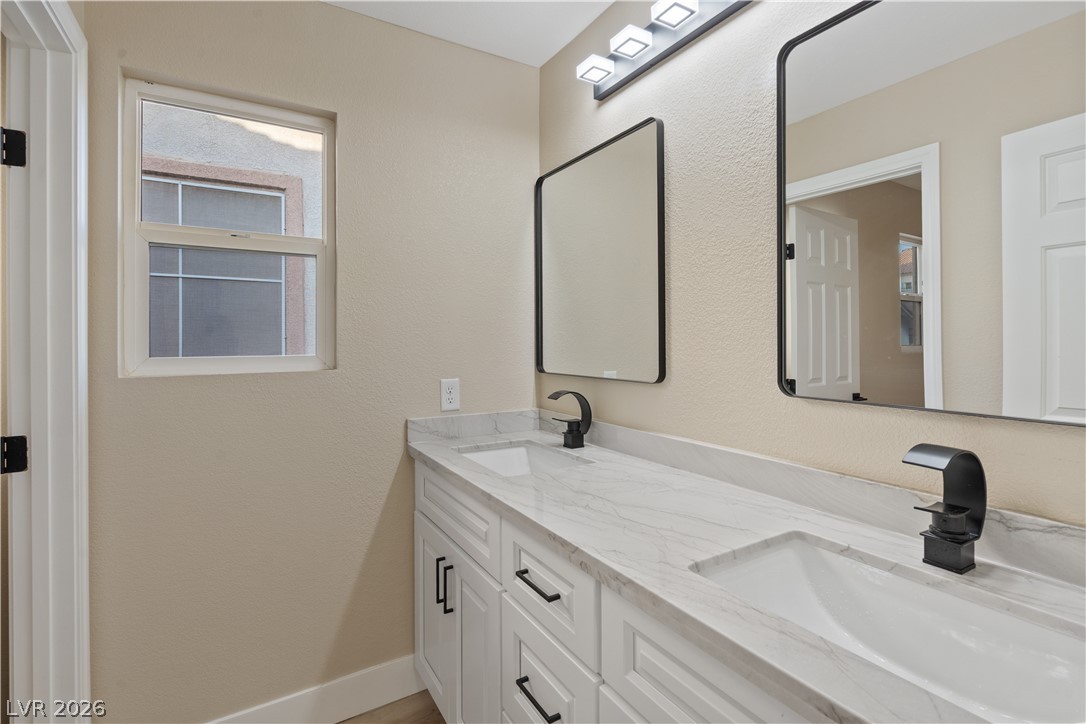 1662 Ravanusa Drive Henderson, NV 89052 - Photo 28 of 74 Dual vanities with elegant black fixtures and pristine countertops enhance this well-appointed bathroom.