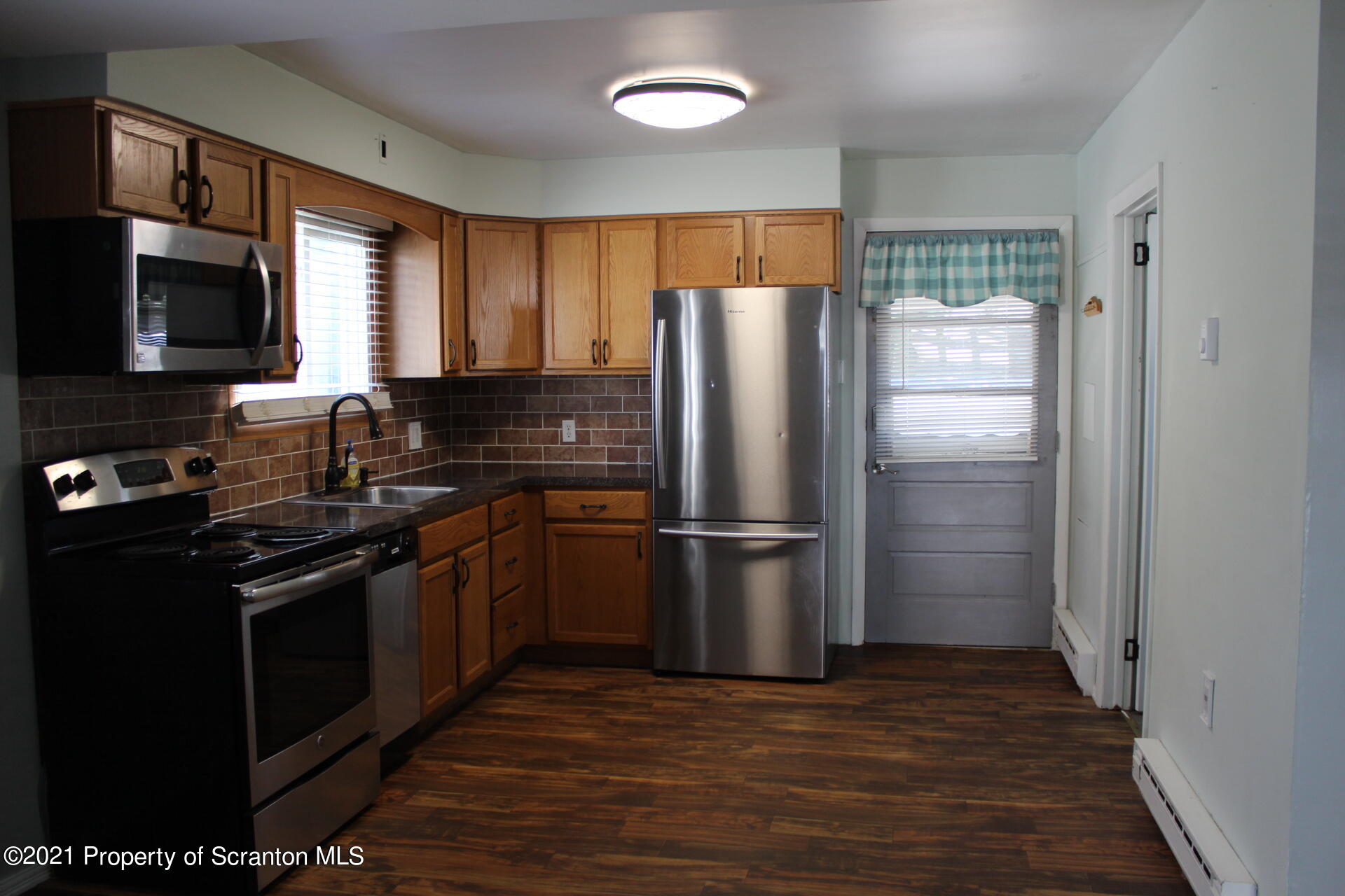 518 Spring Street Moosic, PA 18507 - Photo 3 of 26 a kitchen with a refrigerator sink and wooden floor