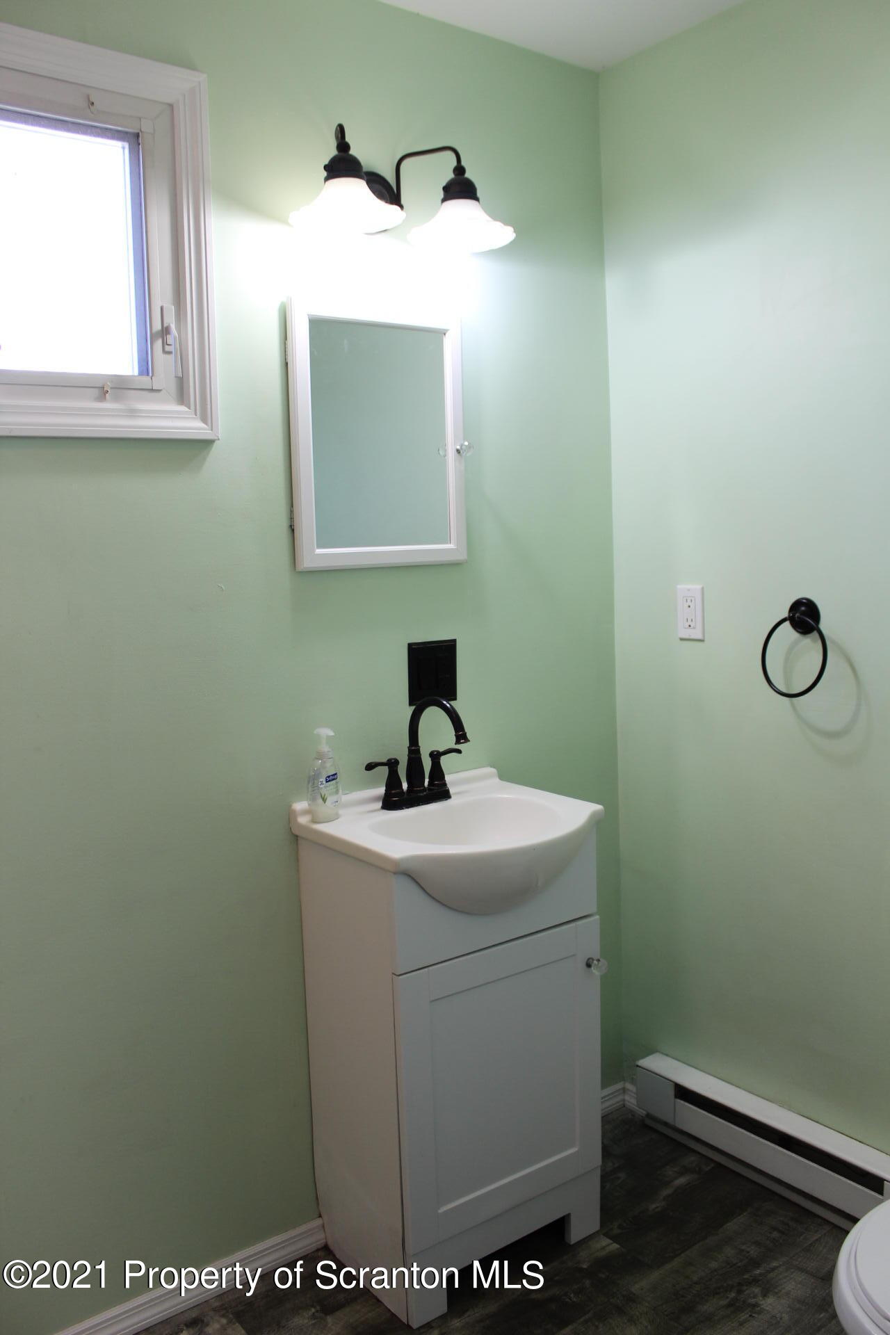 518 Spring Street Moosic, PA 18507 - Photo 5 of 26 a bathroom with a toilet sink vanity and mirror
