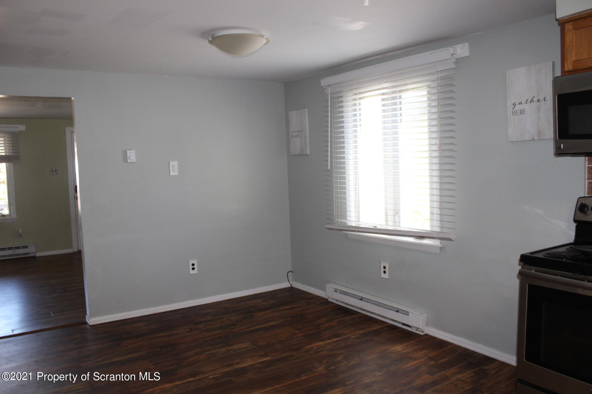 518 Spring Street Moosic, PA 18507 - Photo 8 of 26 an empty room with wooden floor and windows