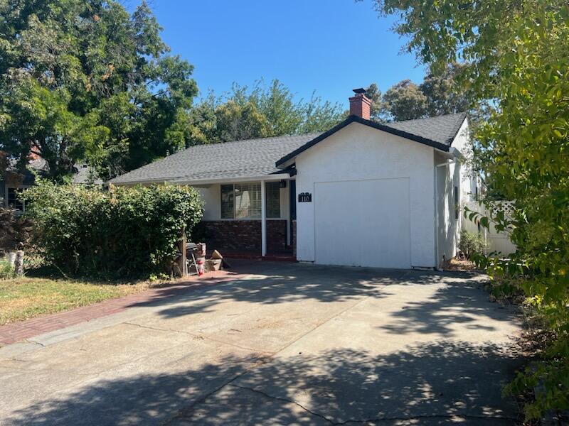 a view of house with yard and trees in the background
