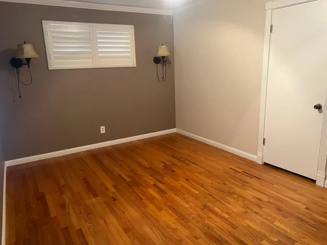 a view of a room with wooden floor and a window