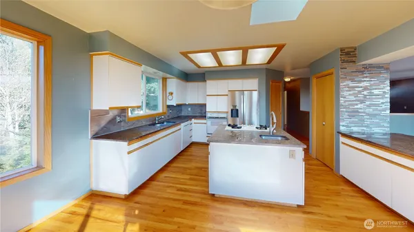 a large kitchen with stainless steel appliances granite countertop a large counter top a stove and a refrigerator