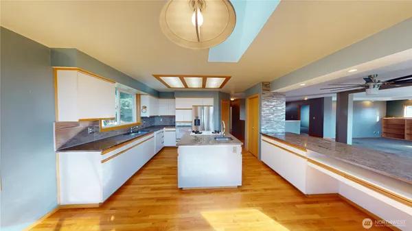 a kitchen with stainless steel appliances granite countertop a sink and a wooden floors