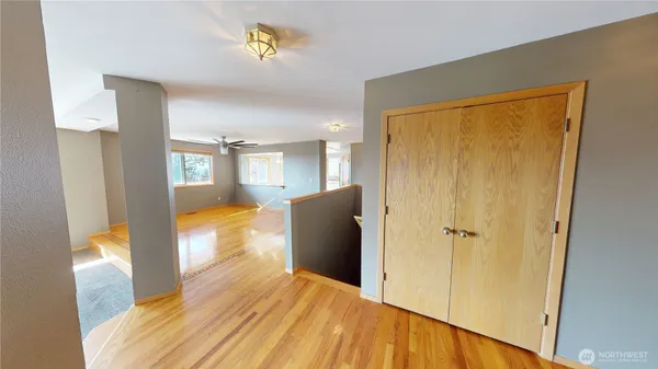 a view of a hallway with wooden floor and cabinet