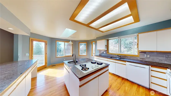 a kitchen with kitchen island granite countertop a stove and a large window