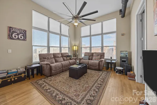a living room with furniture a large window and a rug