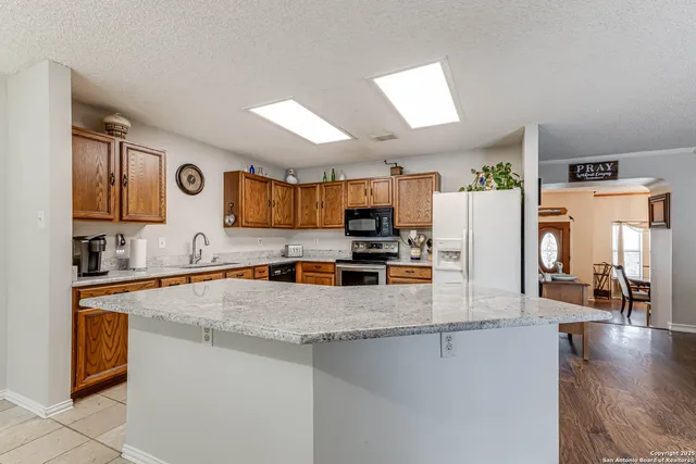 a kitchen with stainless steel appliances granite countertop a sink stove and refrigerator