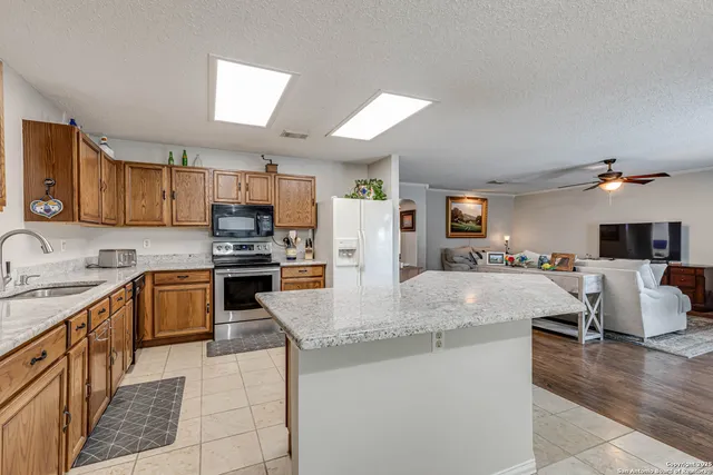 a kitchen with stainless steel appliances granite countertop a sink dishwasher stove top oven and refrigerator