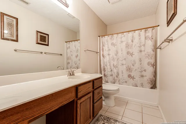 a bathroom with a sink a toilet a shower curtain and a bath tub