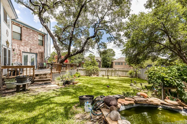 a view of swimming pool with lawn chairs and iron fence