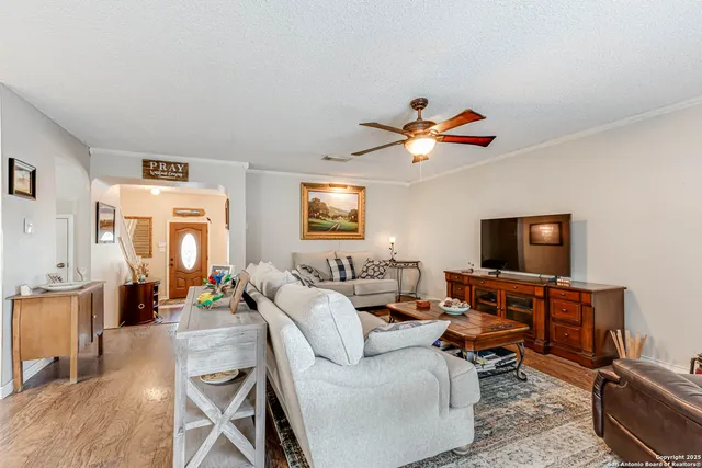 a living room with furniture a flat screen tv and kitchen view