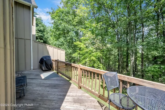 a view of deck with furniture and trees