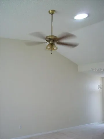 a view of a room with a chandelier fan and wooden floor