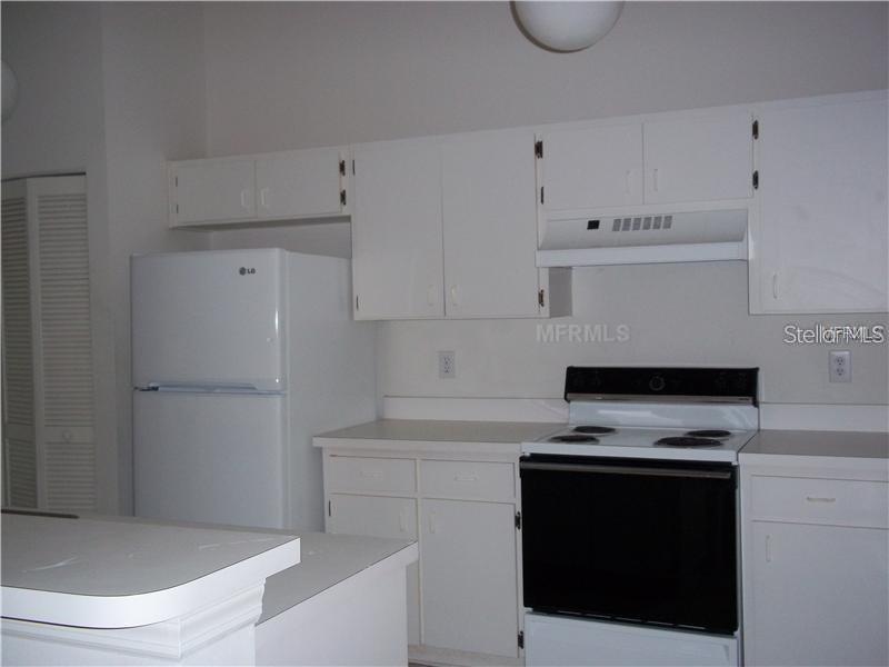2464 Nantucket Harbor Loop, Unit 96 Sun City Center, FL 33573 - Photo 8 of 19 a kitchen with white cabinets and white appliances