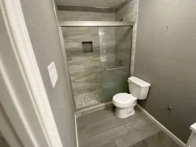 a bathroom with a toilet and a shower