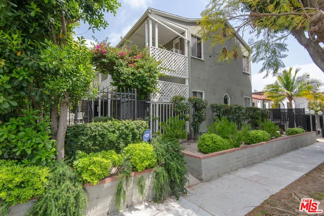 a front view of a house with a yard and potted plants