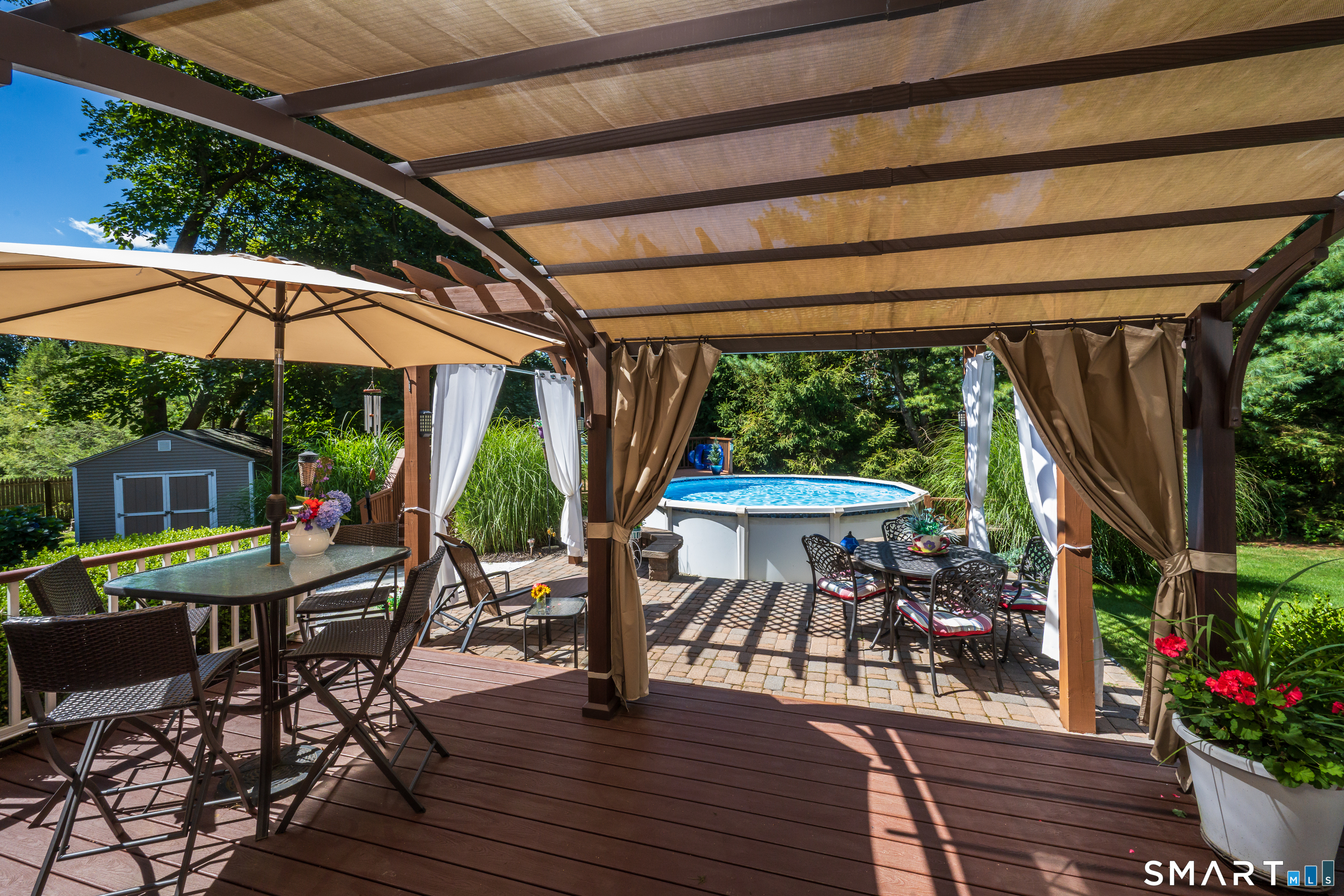 427 Long Mountain Road New Milford, CT 06776 - Photo 38 of 40 a view of a patio with table and chairs under an umbrella with a small yard