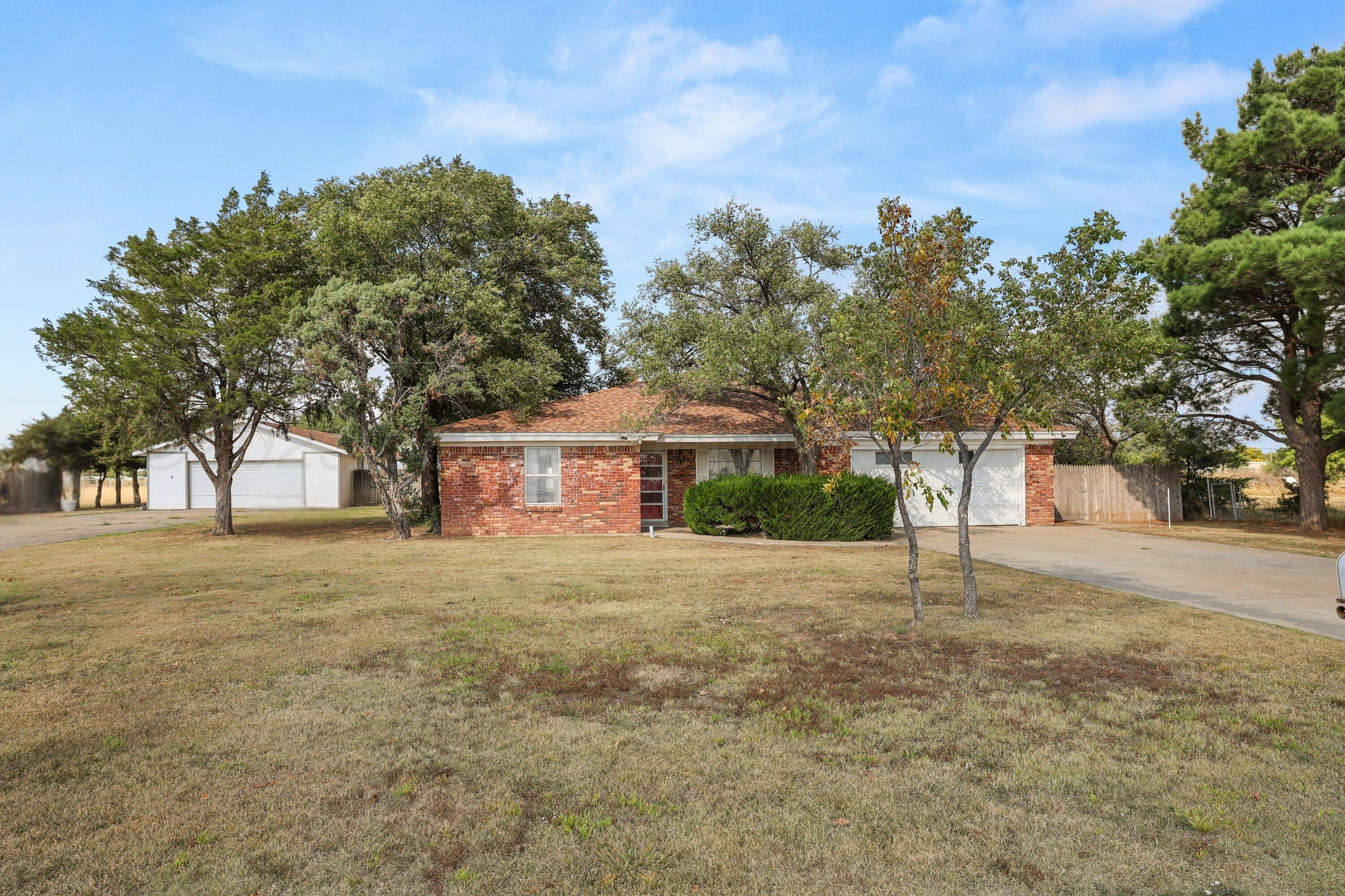 a front view of a house with a yard and tree