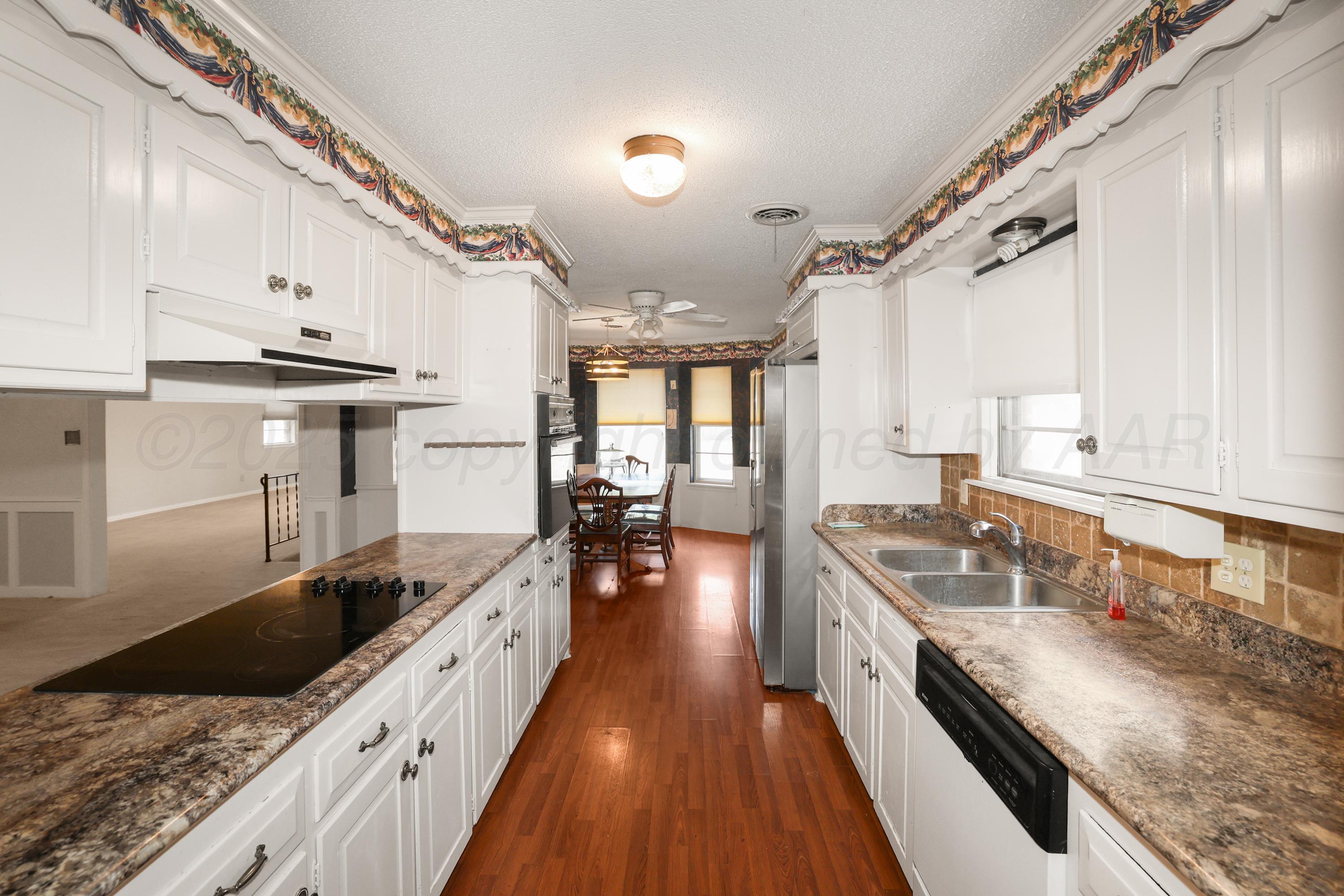 7682 Back Acres Road Amarillo, TX 79119 - Photo 6 of 27 a large kitchen with granite countertop a lot of counter space and wooden floor