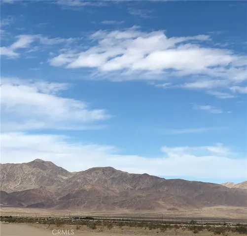 a view of mountain with sunset in background