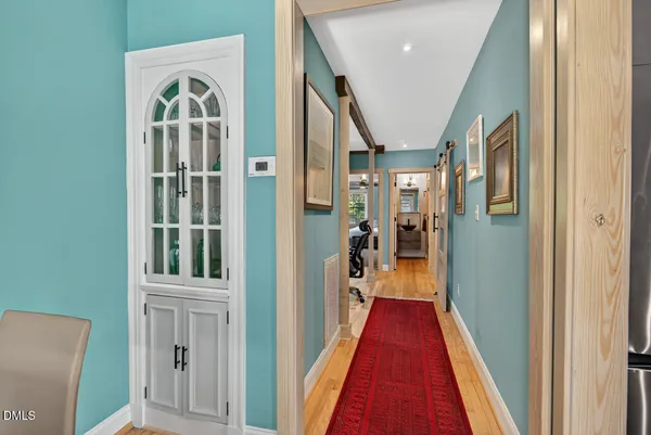 a view of a hallway with wooden floor and entryway