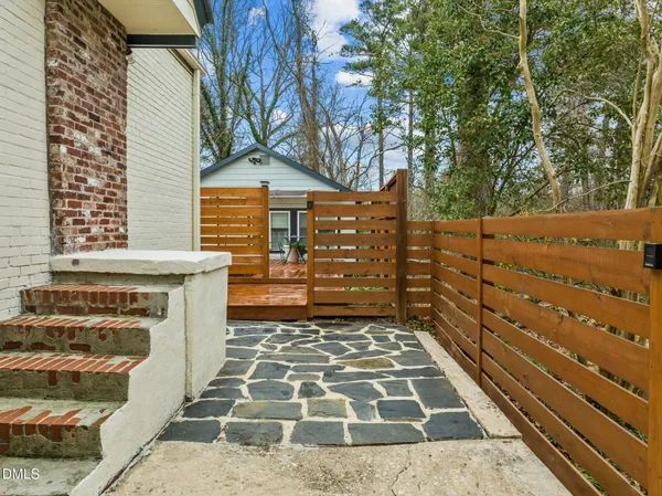 a view of a backyard with wooden fence and trees