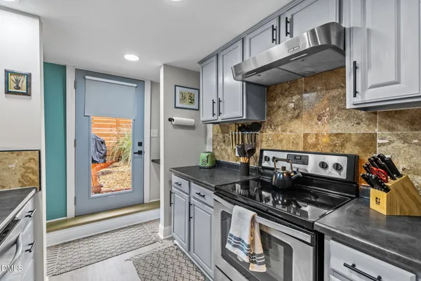 a kitchen with stainless steel appliances granite countertop a stove and a refrigerator