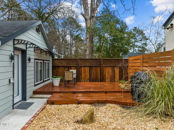 a view of backyard with wooden fence and large trees