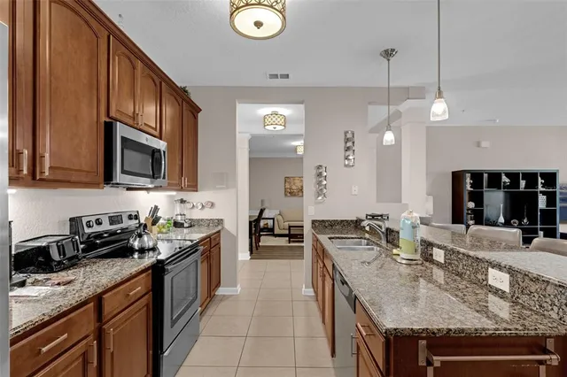 a kitchen with stainless steel appliances granite countertop a stove a refrigerator a sink and a granite counter tops