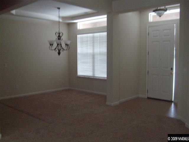 10075 Bull Rider Court Reno, NV 89521 - Photo 2 of 9 en empty room with windows and chandelier fan