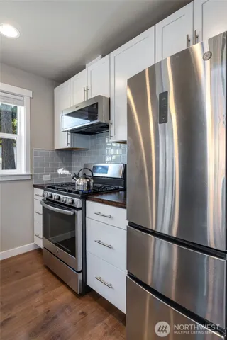 a kitchen with stainless steel appliances a refrigerator stove and microwave