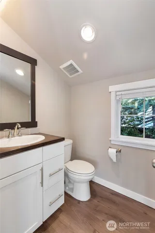 a bathroom with a toilet a sink and mirror