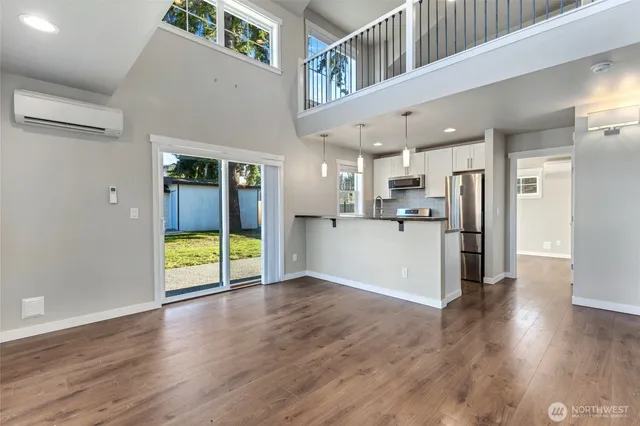 a view of a kitchen with a fridge and wooden floor