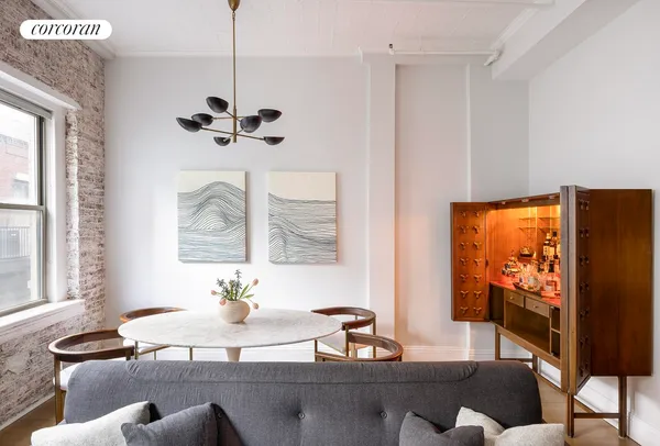 a view of a dining room with furniture a chandelier and wooden floor