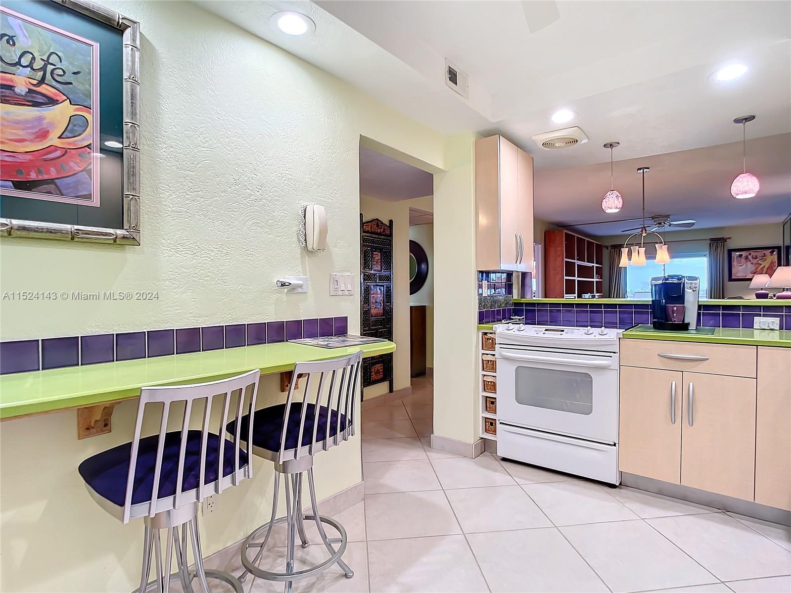 320 South Surf Road, Unit 506 Hollywood, FL 33019 - Photo 9 of 36 a kitchen with stainless steel appliances kitchen island granite countertop a table and chairs in it