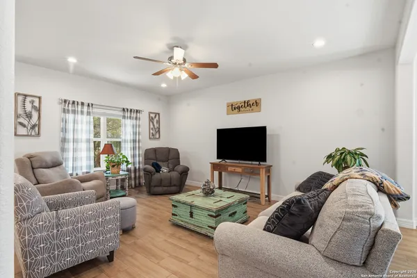 a living room with furniture a flat screen tv and a large window