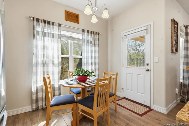 a dining room with furniture a chandelier and wooden floor