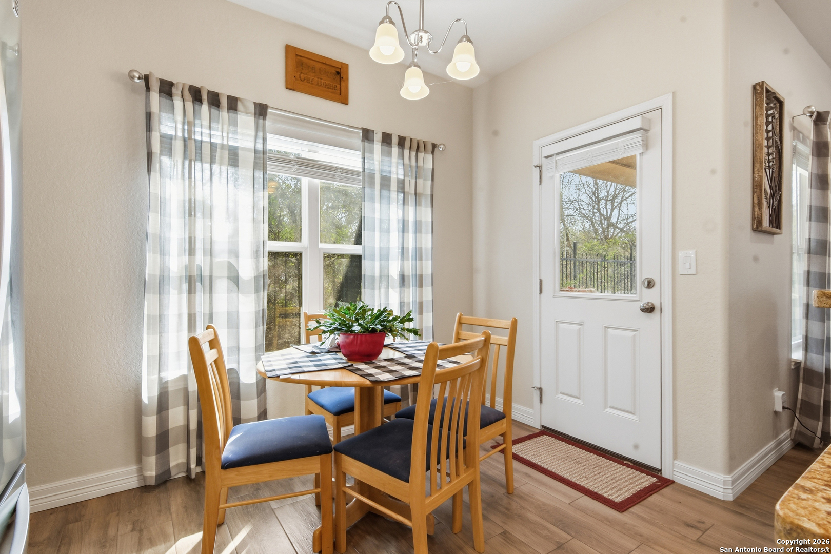 101 Sutton Place Uvalde, TX 78801 - Photo 19 of 36 a dining room with furniture a chandelier and wooden floor