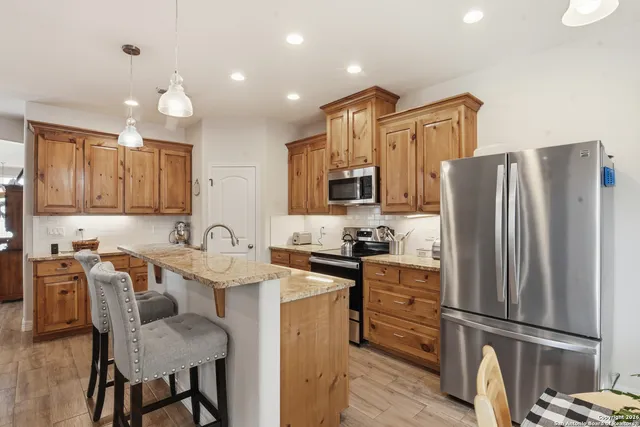 a kitchen with granite countertop a refrigerator stove microwave and sink