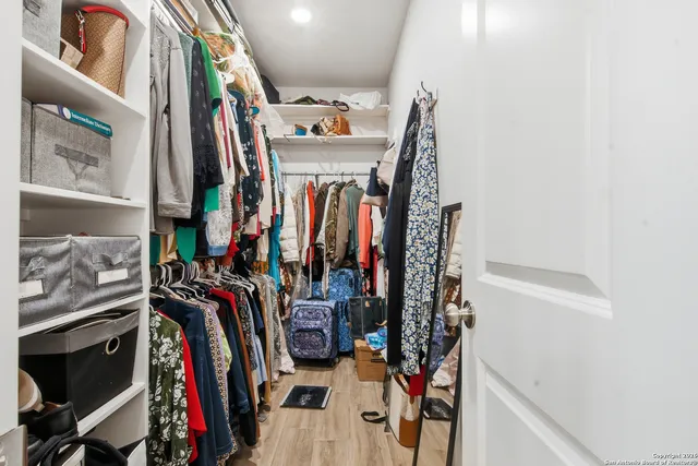 a view of walk in closet with clothes