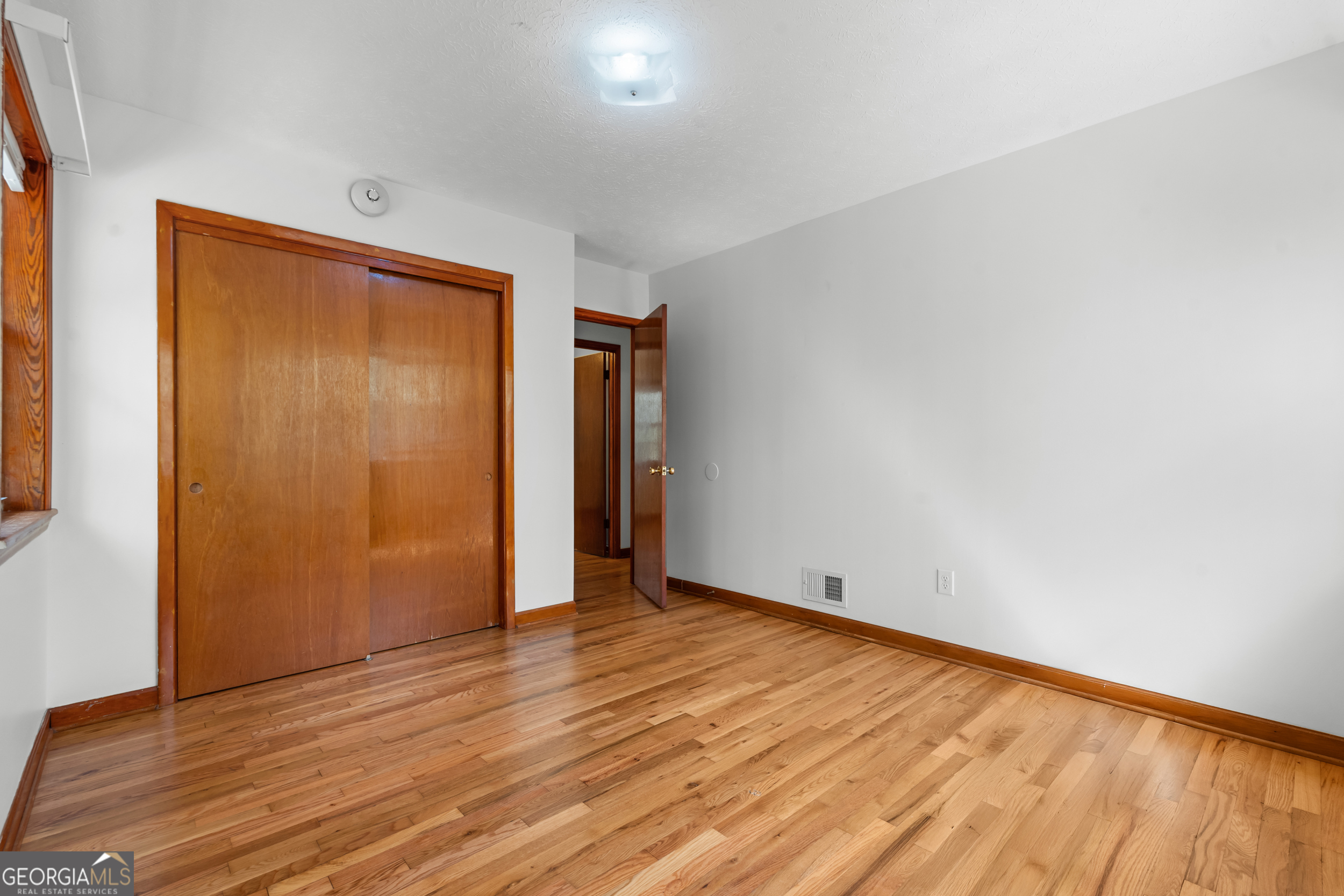 181 Heidt Road Guyton, GA 31312 - Photo 15 of 24 a view of an empty room with wooden floor and closet